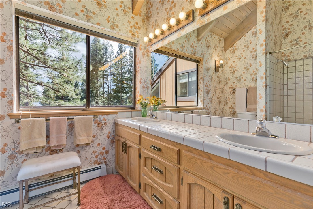 607 Crystal Peak Road Incline Village, NV 89451 - Photo 18 of 34 a bathroom with a granite countertop sink mirror and a large window