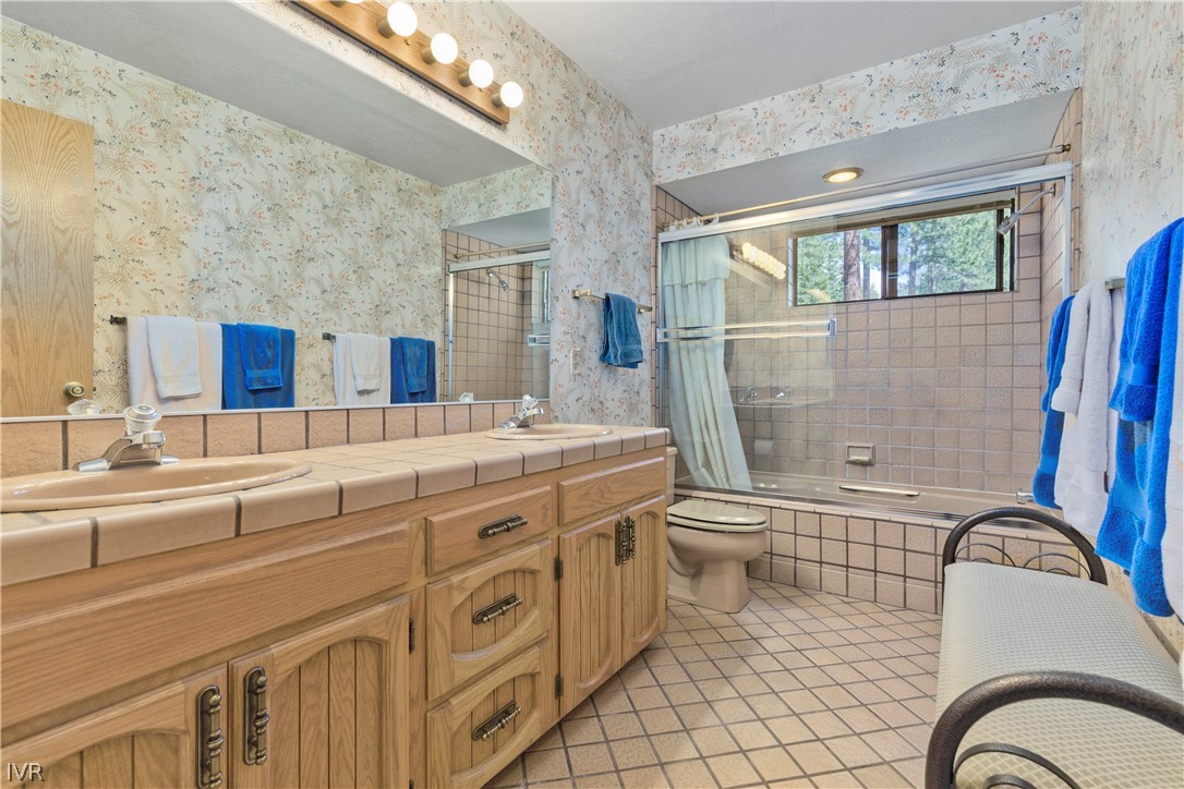 607 Crystal Peak Road Incline Village, NV 89451 - Photo 24 of 34 a bathroom with a granite countertop double vanity sink a mirror and a shower