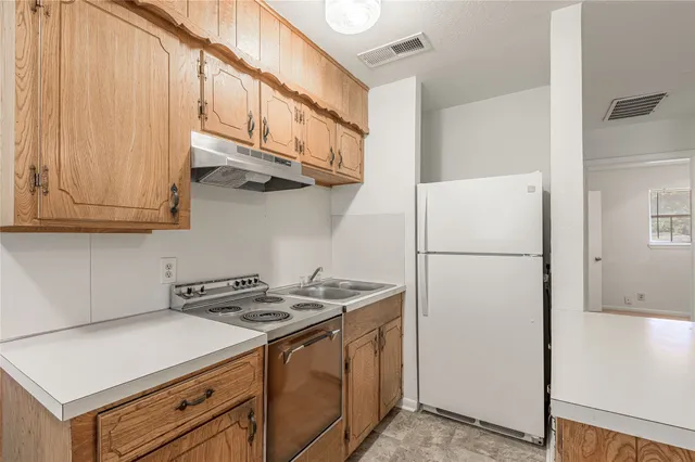 a kitchen with stainless steel appliances granite countertop a refrigerator a stove and a sink with cabinets