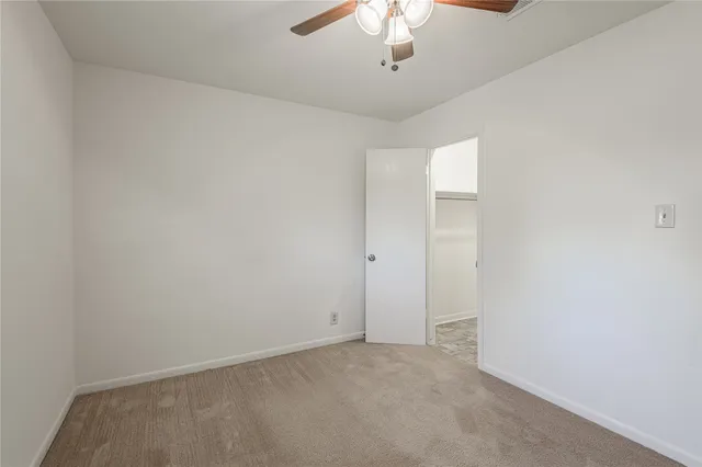 an empty room with a chandelier fan