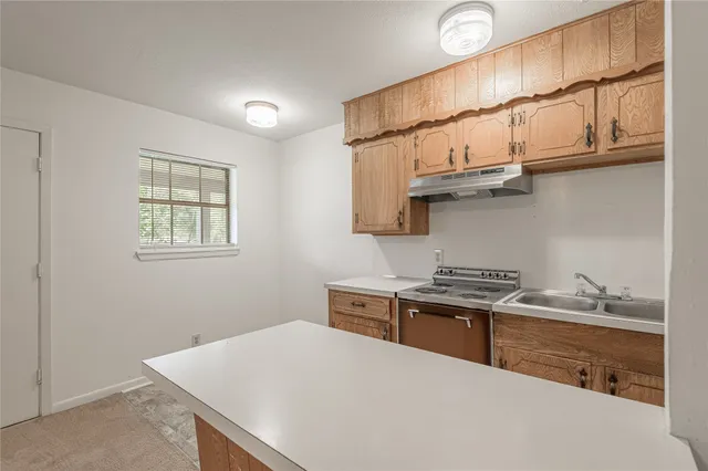 a kitchen with stainless steel appliances a stove a sink and cabinets