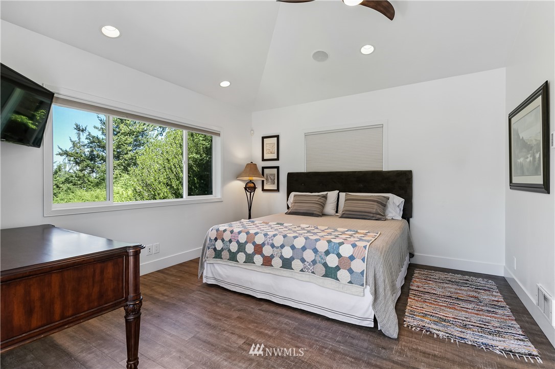 245 Middlefield Road Bellingham, WA 98225 - Photo 32 of 40 a bedroom with a bed and a flat tv screen on dresser