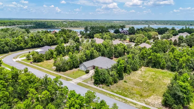 an aerial view of a house with a yard and lake view