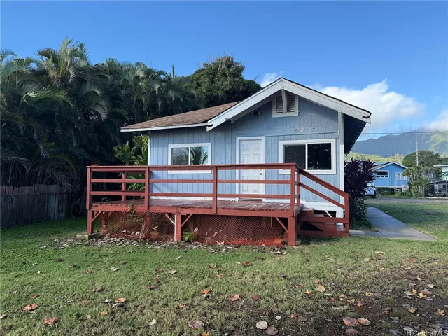 a backyard of a house with wooden fence and large trees