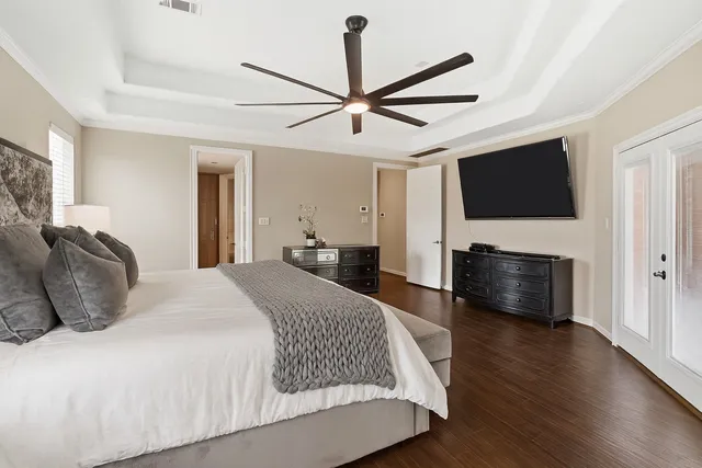 a bedroom with a bed a flat screen tv and a couch