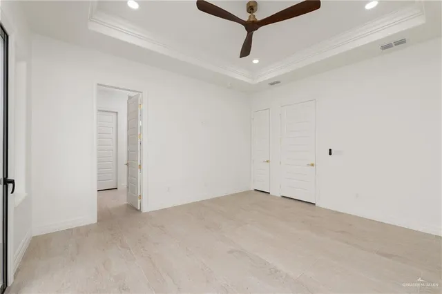 an empty room with a ceiling fan and wooden floor