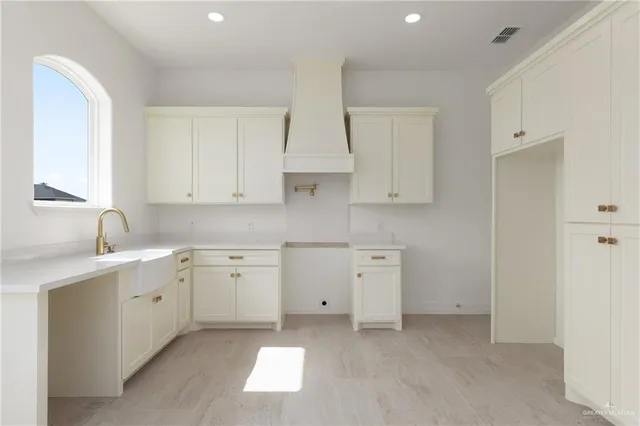 a kitchen with white cabinets stainless steel appliances and sink