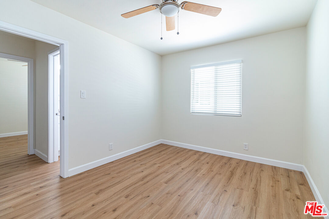 12572 Washington Boulevard, Unit 2 Los Angeles, CA 90066 - Photo 1 of 19 an empty room with wooden floor chandelier fan and windows