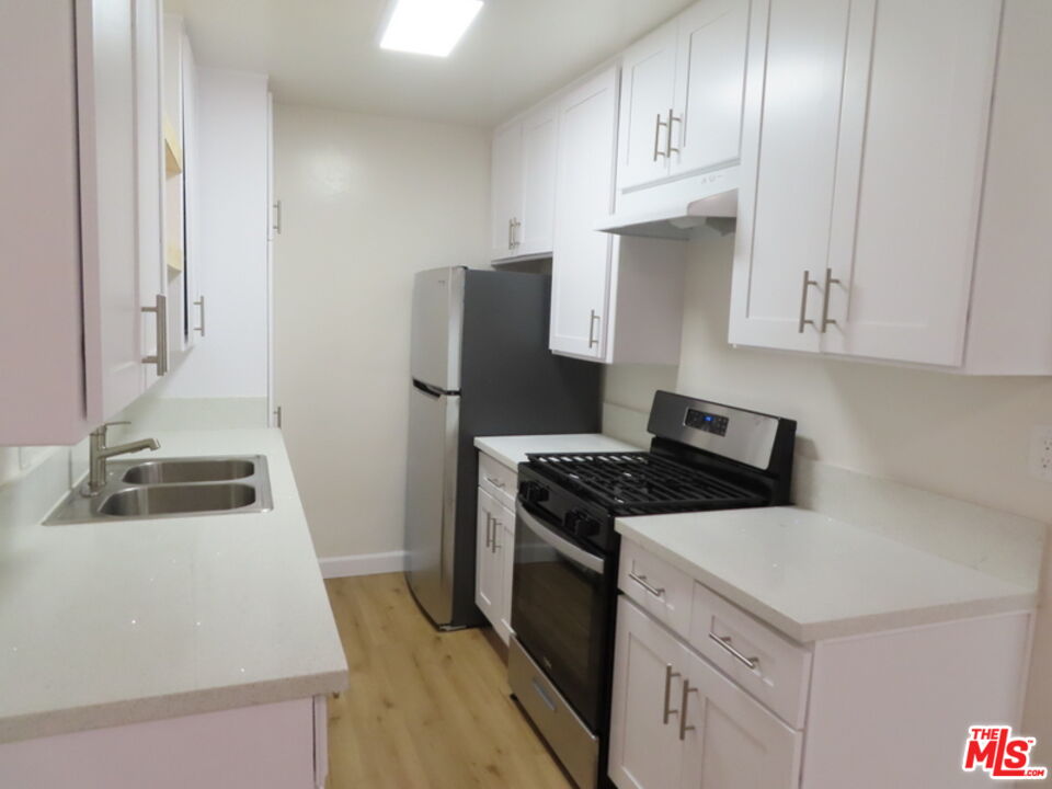 12572 Washington Boulevard, Unit 2 Los Angeles, CA 90066 - Photo 17 of 19 a kitchen with granite countertop a sink stove and refrigerator