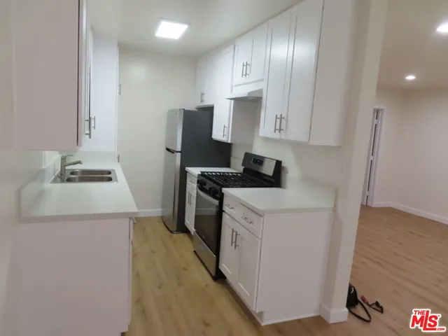 a kitchen with a sink a stove and a refrigerator