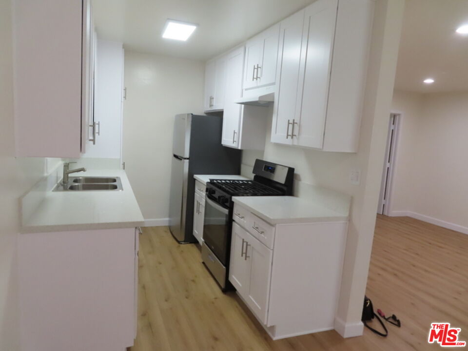 12572 Washington Boulevard, Unit 2 Los Angeles, CA 90066 - Photo 18 of 19 a kitchen with a sink a stove and a refrigerator