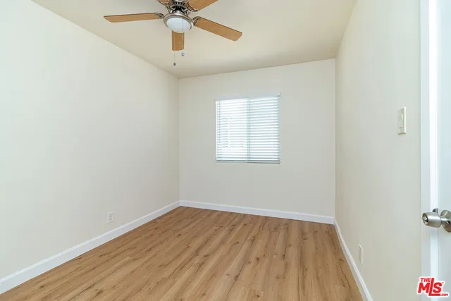 an empty room with a window and a ceiling fan