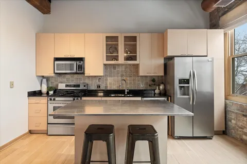 a kitchen with appliances a sink and cabinets