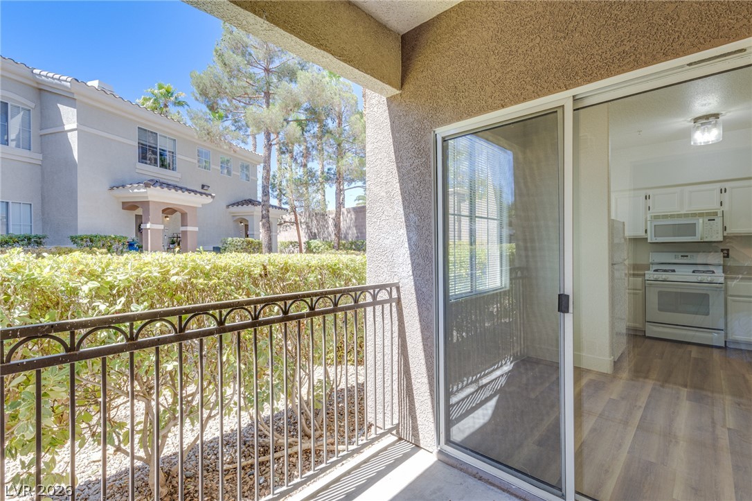 9050 West Warm Springs Road, Unit 1011 Las Vegas, NV 89148 - Photo 8 of 32 A private outdoor space with durable iron railings offers serene views of lush landscaping and nearby architecture.