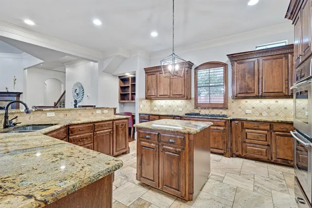 a kitchen with stainless steel appliances granite countertop wooden cabinets sink and stove