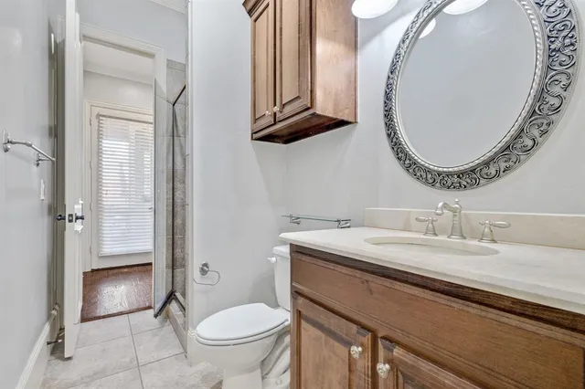 a bathroom with a granite countertop toilet a sink and mirror
