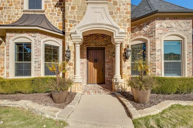 a view of a brick house with potted plants