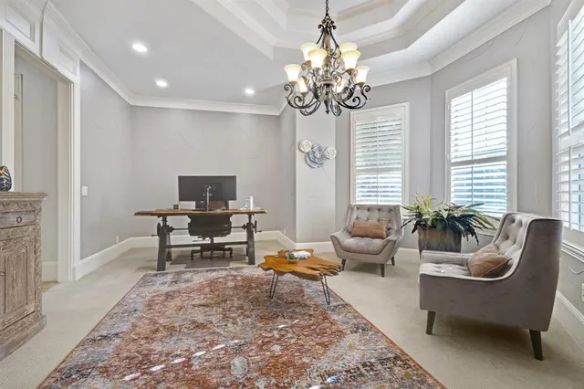 a living room with furniture a chandelier and a rug
