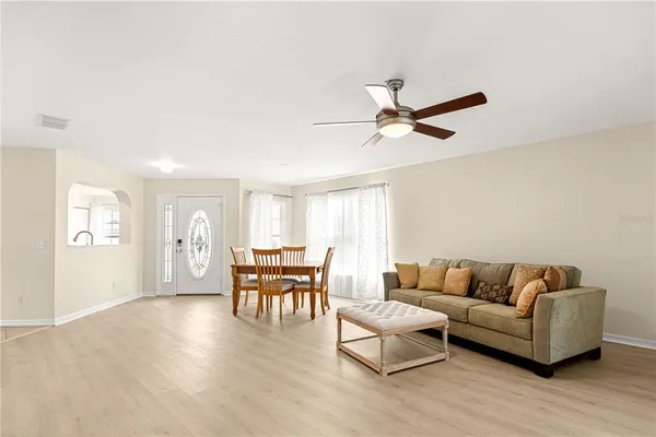 a living room with furniture and a ceiling fan