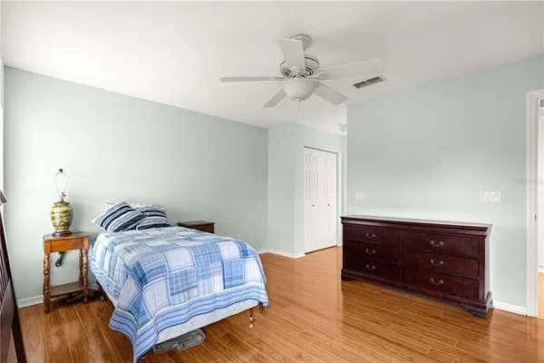 a bedroom with a bed and wooden floor