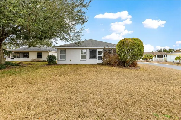 a view of a house with a yard and potted plants