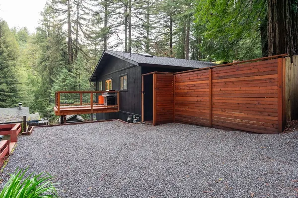 a view of a house with a backyard space and wooden fence