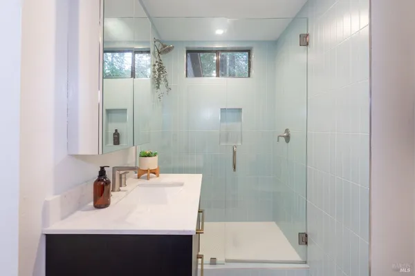 a bathroom with a sink a shower and a mirror