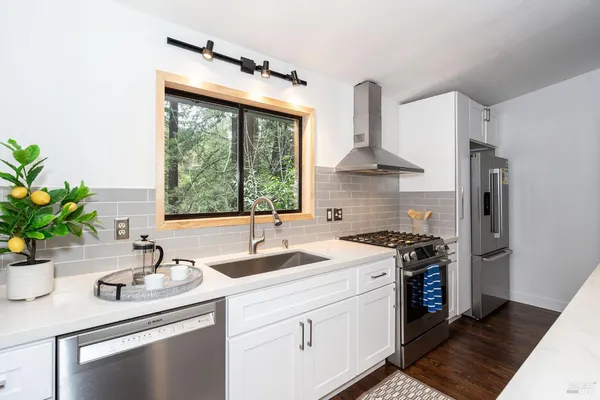 a kitchen with stainless steel appliances a sink a stove and a window