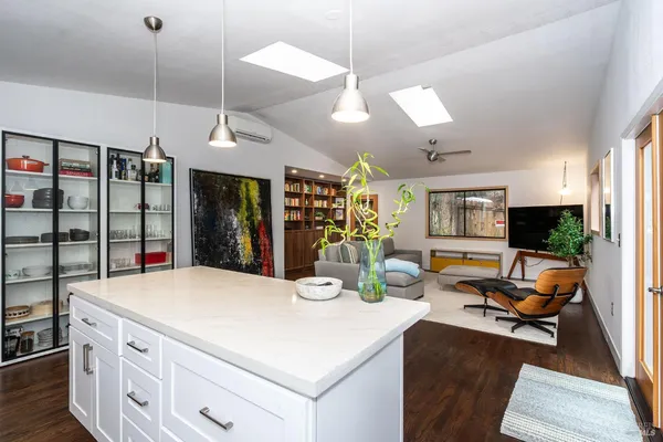 a kitchen with a refrigerator a stove and a dining table with wooden floor