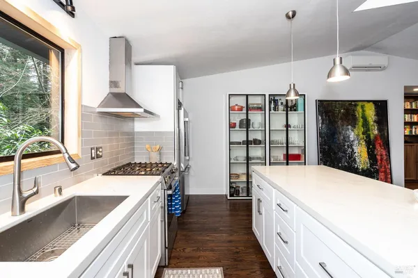 a large kitchen with a large window a sink dishwasher and a stove