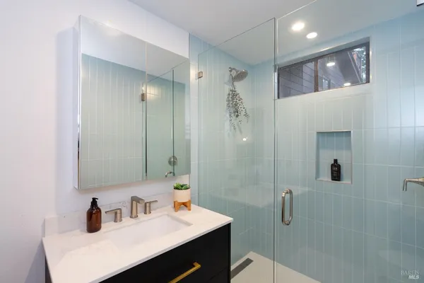 a bathroom with a sink a toilet and shower