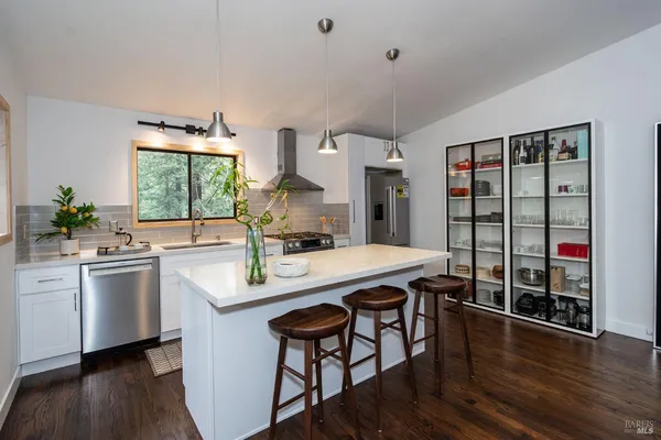 a kitchen with stainless steel appliances a table and chairs in it