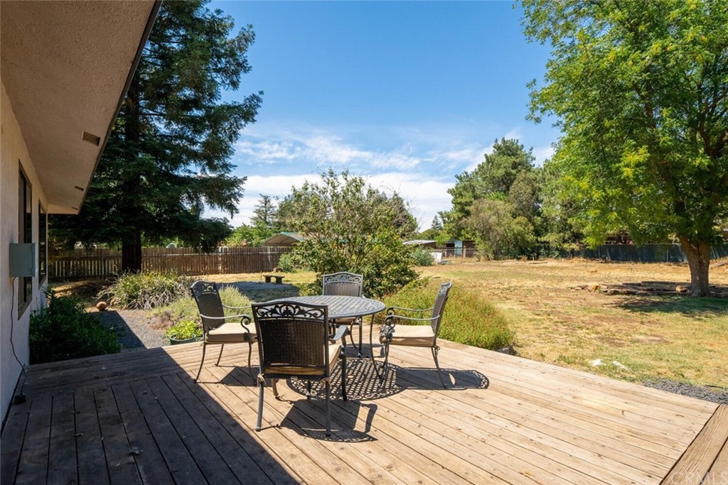 4312 Stable Lane Chico, CA 95973 - Photo 37 of 50 a view of a patio with dining table and chairs with wooden floor and fence