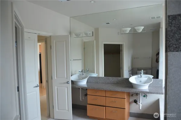 a bathroom with a granite countertop sink and a mirror