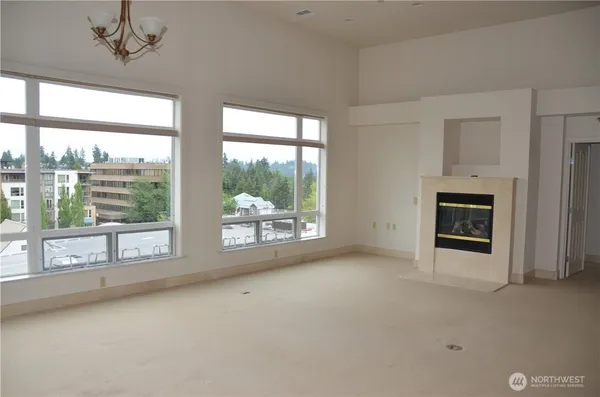 a view of an empty room with a fireplace and a window