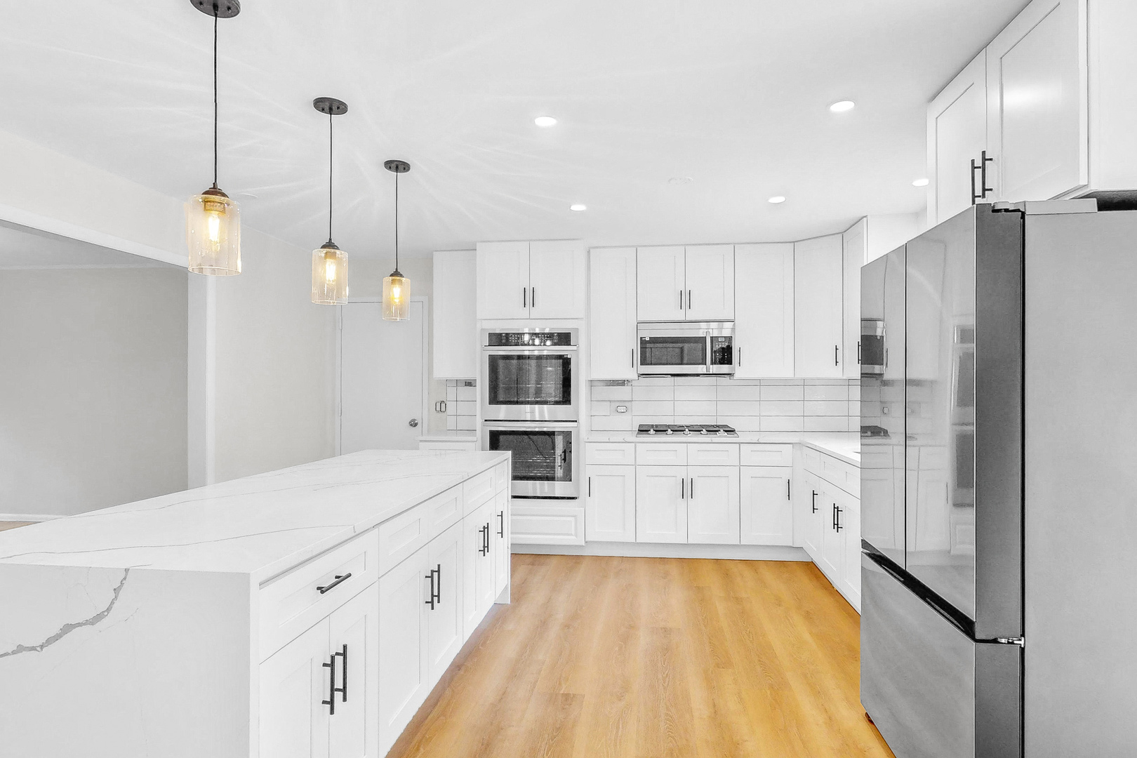 2100 Burr Oak Drive Glenview, IL 60025 - Photo 8 of 38 a large white kitchen with stainless steel appliances and white cabinets