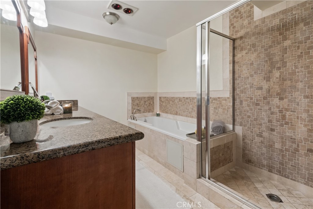 6221 Monterey Road, Unit 304 Highland Park, CA 90042 - Photo 22 of 27 a bathroom with a granite countertop sink a mirror and shower