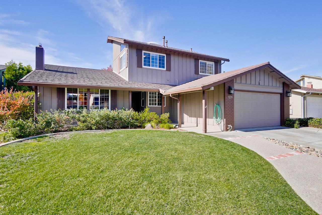 a front view of a house with a garden and plants