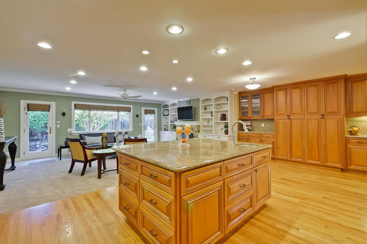 1229 Rousseau Drive Sunnyvale, CA 94087 - Photo 14 of 37 a kitchen with kitchen island granite countertop a sink cabinets and living room view