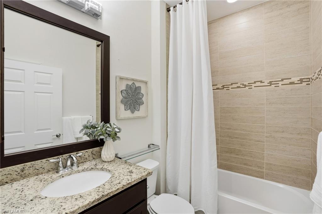 10520 Tidewater Key Boulevard Estero, FL 33928 - Photo 23 of 50 a bathroom with a granite countertop sink and a mirror