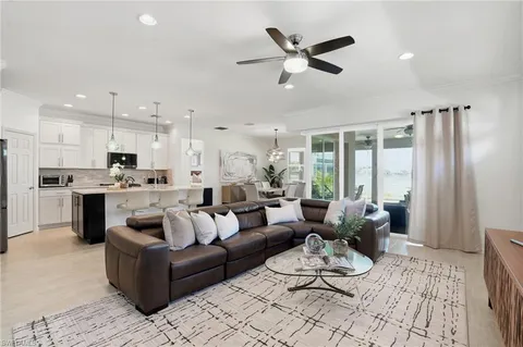 a living room with furniture kitchen and a chandelier