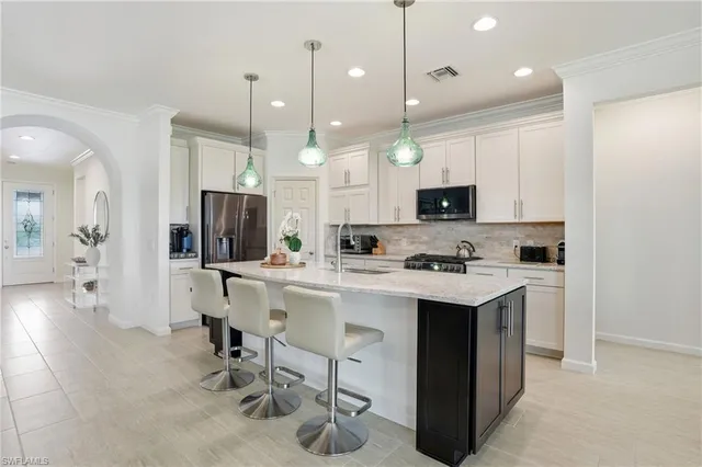 a kitchen with a sink a center island stainless steel appliances and cabinets