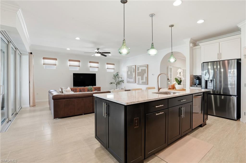10520 Tidewater Key Boulevard Estero, FL 33928 - Photo 10 of 50 a kitchen with a refrigerator a sink and a flat screen tv