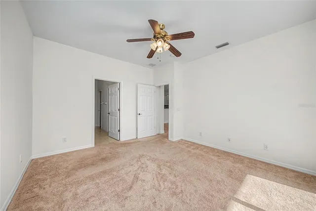 an empty room with window and ceiling fan
