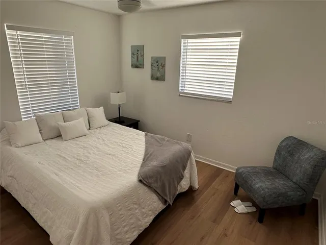 a bedroom with a bed and wooden floor