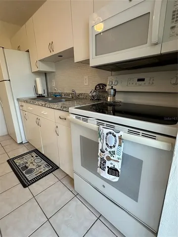 a kitchen with stainless steel appliances a stove a microwave and a sink