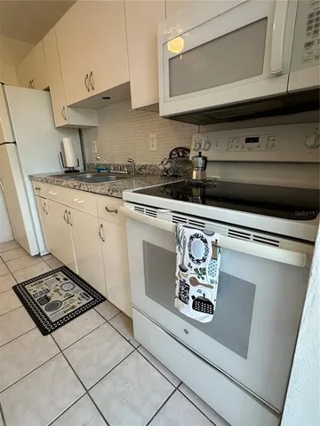 a white stove top oven sitting inside of a kitchen
