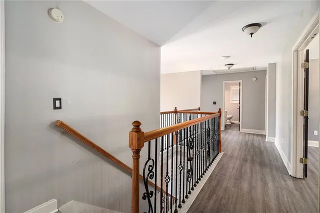 an empty room with wooden floor chandelier fan and windows
