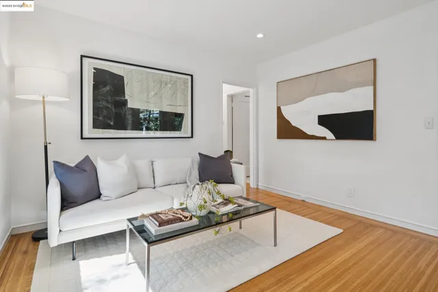 a living room with furniture and a painting on the wall