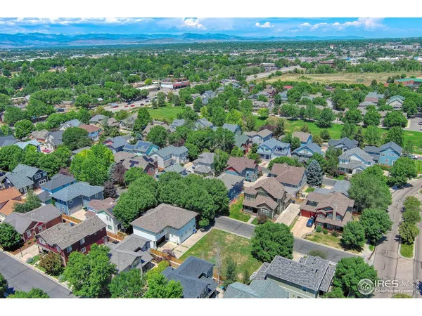 an aerial view of residential houses with outdoor space and trees